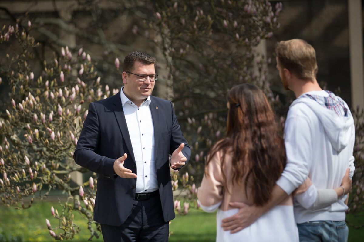 Christian Tylsch spricht mit einem Pärchen im Park.